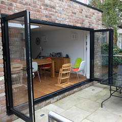 Black bi-folding doors opening on to the patio