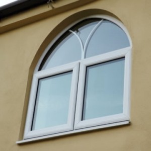 Arched white French window with decorative astragal bars