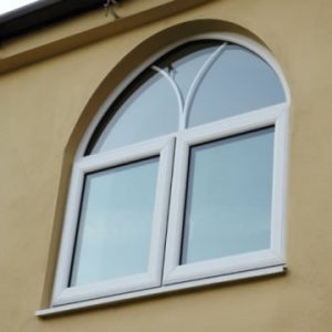 Arched white French window with decorative astragal bars