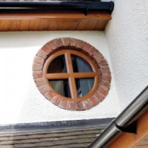 Small woodgrain circular window with cross astragal bar
