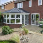 White tiled roof conservatory with black tiled roof.